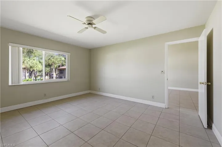 Spacious room featuring neutral-toned walls and square tile flooring