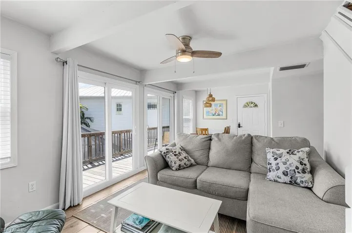 The living room has impact windows and doors leading to the open deck.