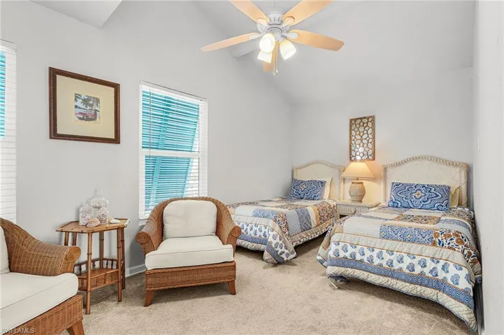 Guest Bedroom #2 with vaulted ceiling, impact windows, Bahama shutters, and a walk-in closet.