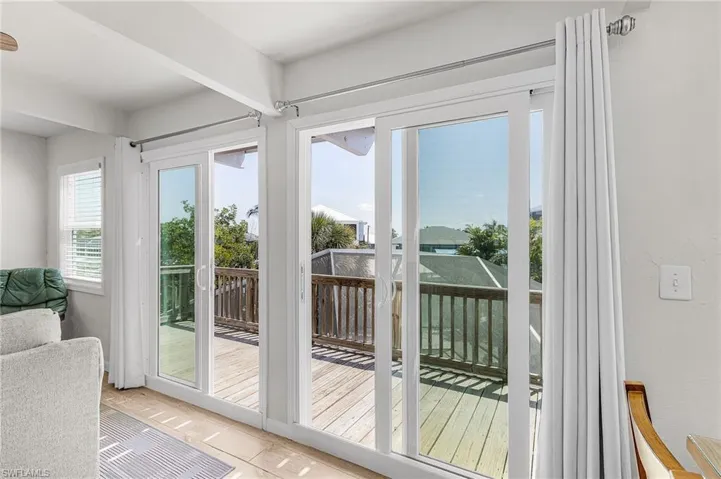 The main living area has impact doors leading to an open deck overlooking the pool.