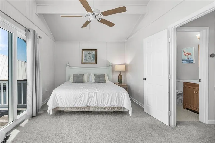 Primary bedroom with private deck overlooking the pool, canal, and St. James City.