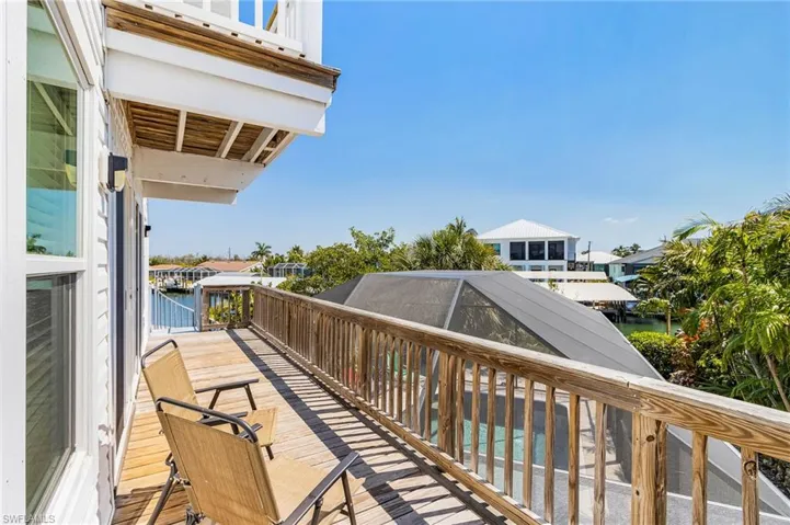 Second-floor deck leading to a staircase down to the pool.