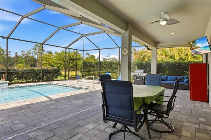View of patio / terrace featuring ceiling fan, a lanai, a sunroom, an outdoor pool, and an outdoor living / dining area