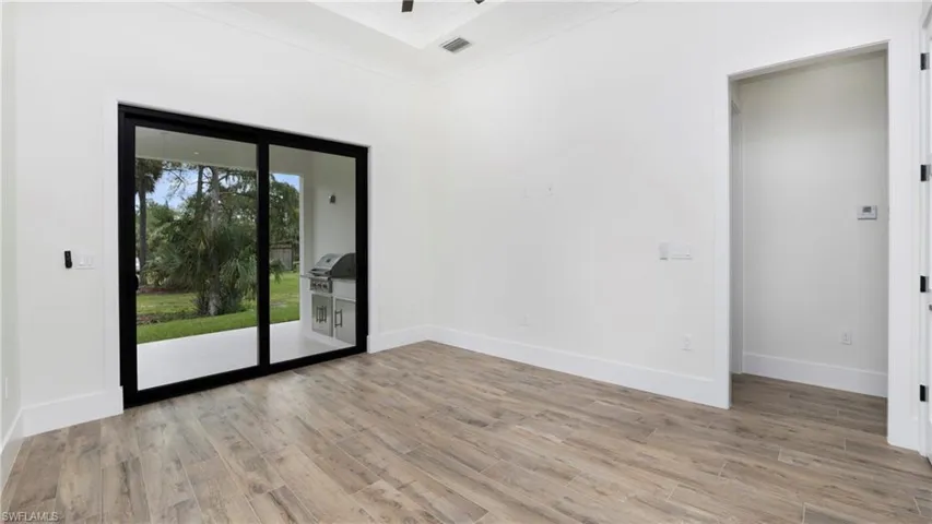 Spare room with ornamental molding and light wood finished floors