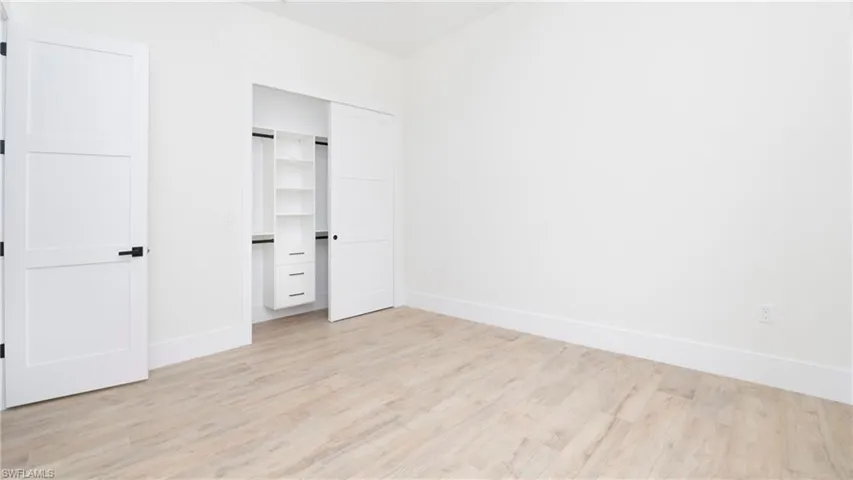 Unfurnished bedroom featuring light wood finished floors and a closet