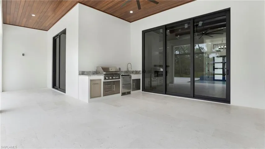 View of patio with exterior kitchen and ceiling fan