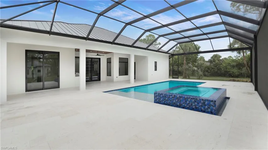 View of pool with a sunroom, a pool with connected hot tub, a patio, and a ceiling fan