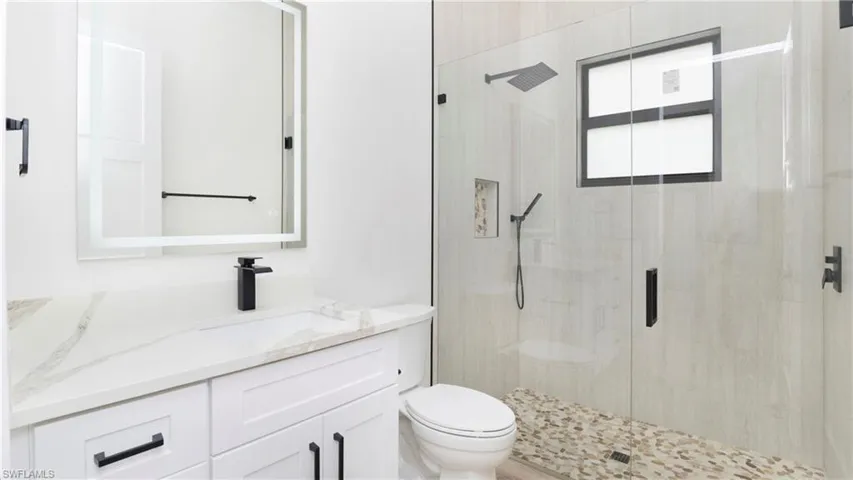 Full bath featuring a stall shower and vanity
