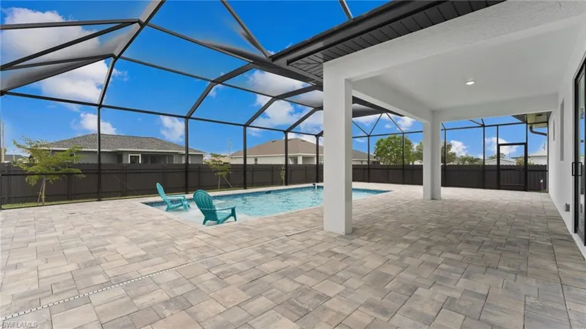 View of pool featuring a patio and glass enclosure