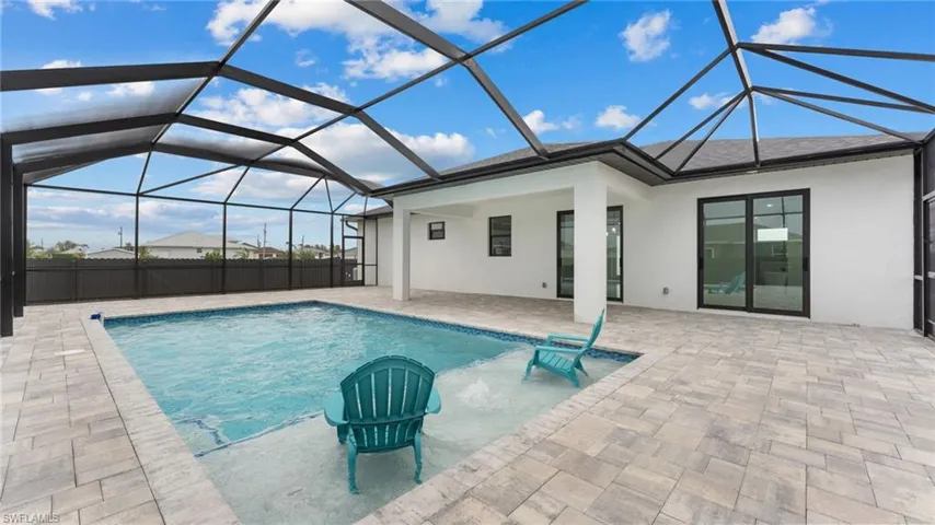 View of swimming pool with glass enclosure and a patio