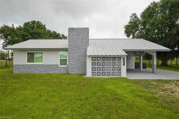 Rear view of house featuring a yard