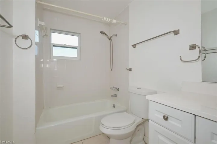 Full bathroom featuring vanity, toilet, tile patterned floors, and tiled shower / bath