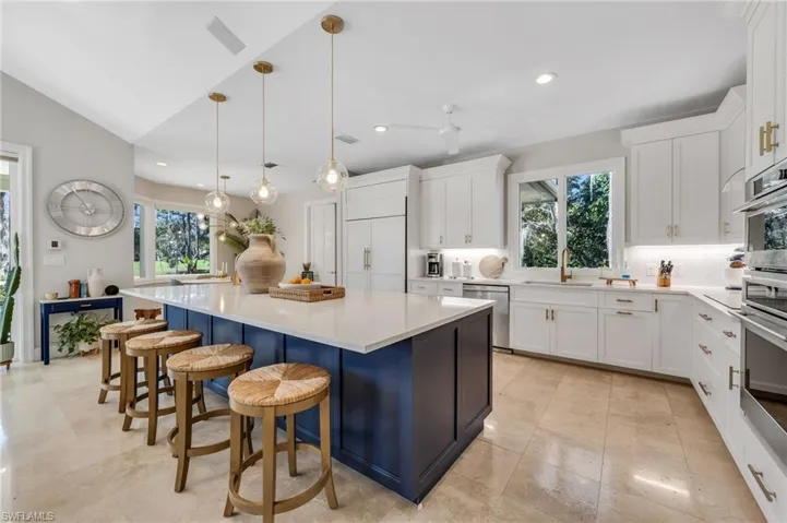 Beautifully remodeled white kitchen with accented island, induction cooktop and Monogram appliances