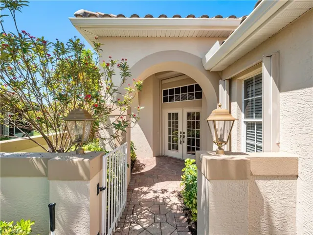 Doorway to property with french doors, a gate, stucco siding, and a patio area