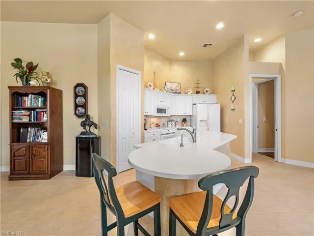 Dining space with light tile patterned floors and recessed lighting