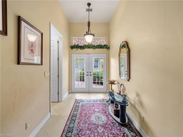 Foyer featuring french doors and light tile patterned floors