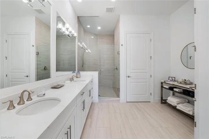 Bathroom with a shower stall, double vanity, and recessed lighting