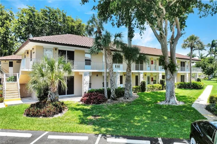 View of front of home with a front lawn and a balcony