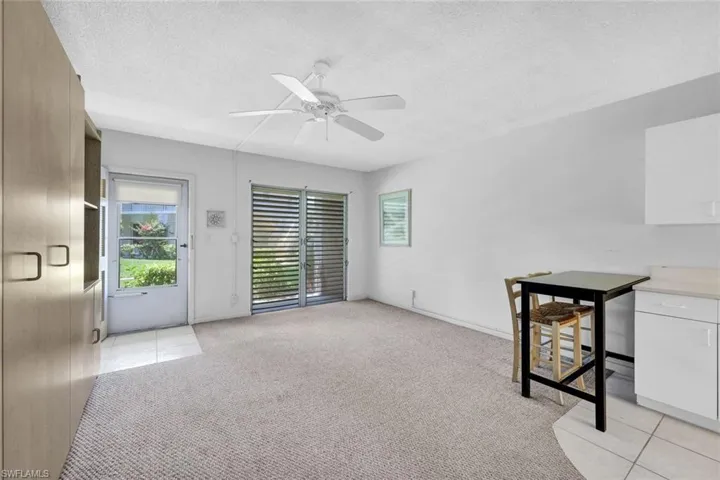 Spare room with light carpet, ceiling fan, and a textured ceiling