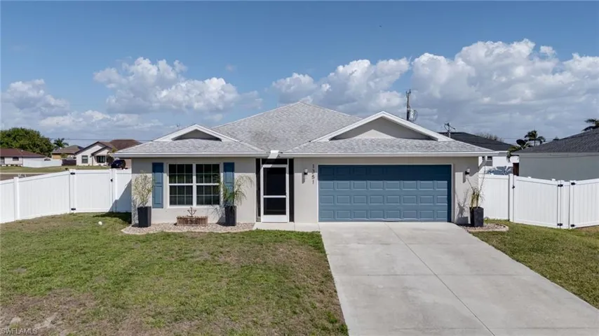 Ranch-style home with a gate, driveway, an attached garage, and stucco siding
