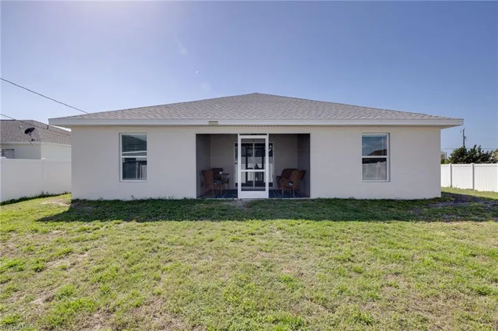 Back of house featuring stucco siding and roof with shingles