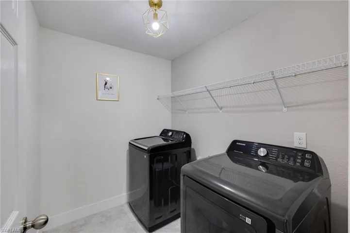 Laundry room with baseboards and washing machine and clothes dryer
