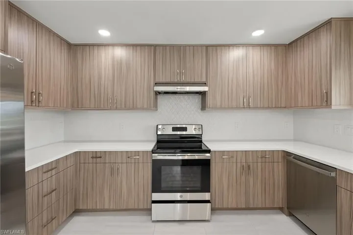 Kitchen with light tile patterned flooring and appliances with stainless steel finishes