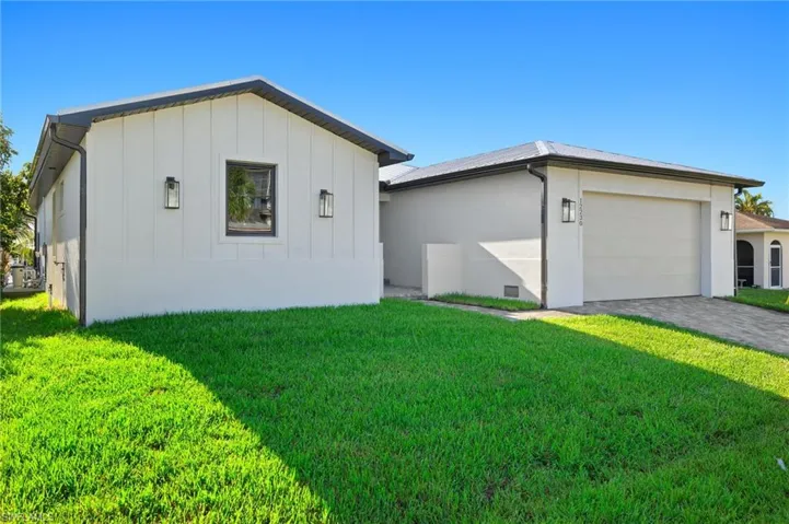 View of front of house with a garage and a front lawn