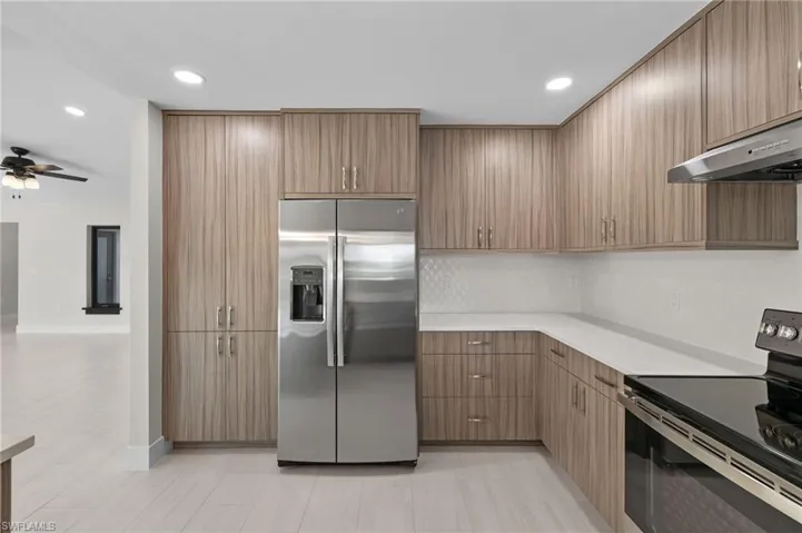 Kitchen with appliances with stainless steel finishes, ceiling fan, and light tile patterned floors