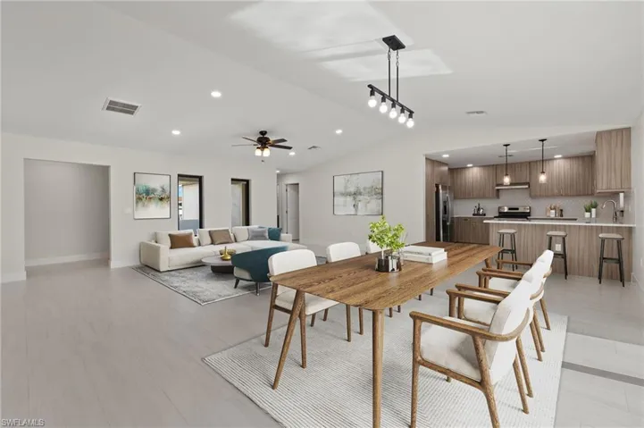 Dining space with ceiling fan, light hardwood / wood-style floors, and lofted ceiling