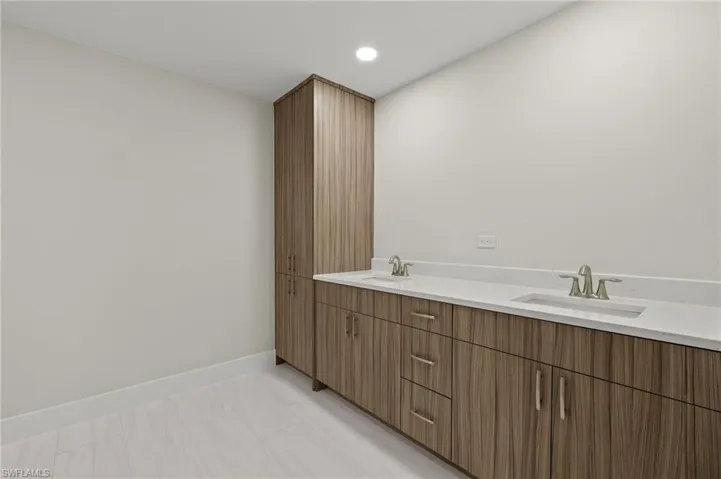 Bathroom featuring tile patterned flooring and dual bowl vanity