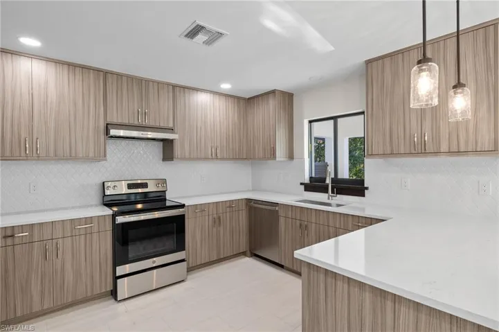 Kitchen featuring light tile patterned floors, stainless steel appliances, tasteful backsplash, and sink