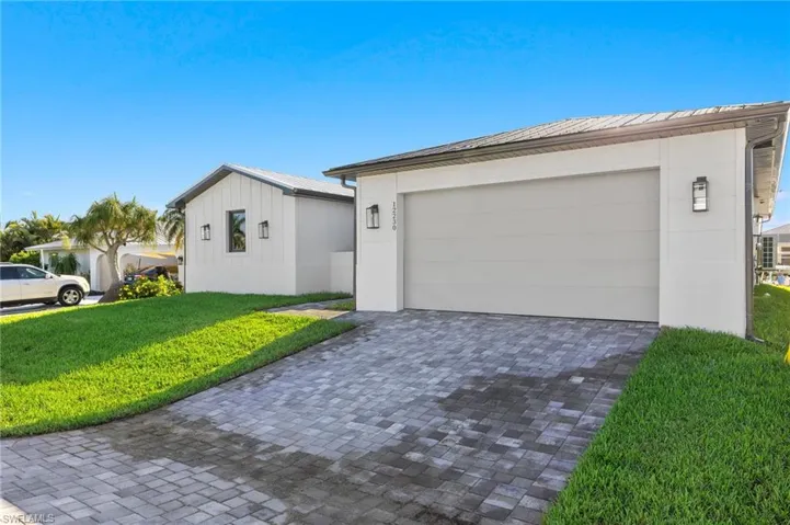 Single story home with a garage and a front lawn