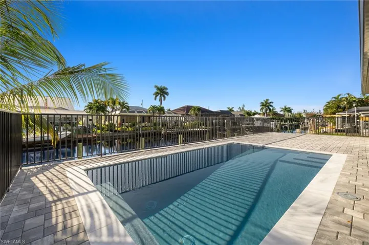 View of swimming pool with a patio area and a water view