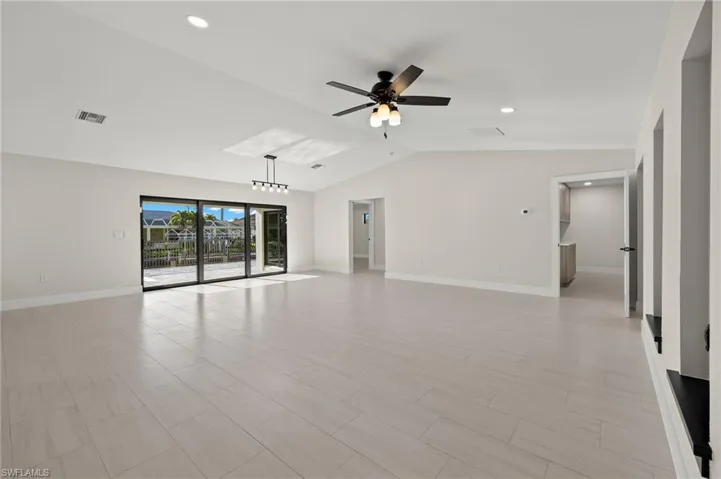 Tiled spare room with vaulted ceiling and ceiling fan