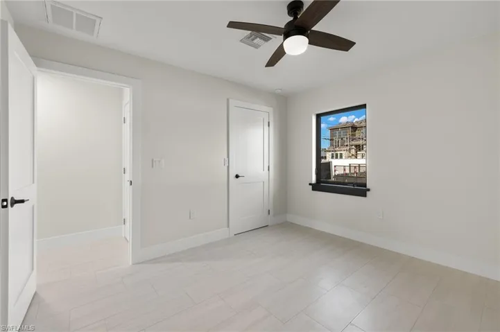 Unfurnished bedroom featuring light tile patterned floors and ceiling fan