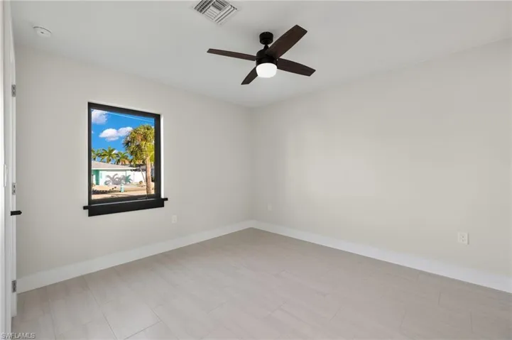 guest bedroom room with light tile patterned floors and ceiling fan