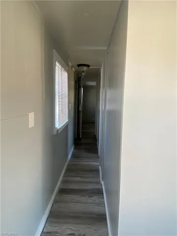 Hallway with baseboards and light wood-style floors