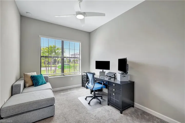 Office space with baseboards, carpet flooring, and a ceiling fan