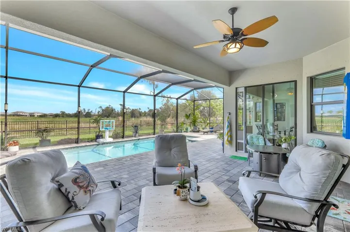 Swimming pool with a patio, ceiling fan, and glass enclosure