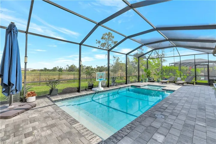 View of pool with a patio, a pool with connected hot tub, and a lanai