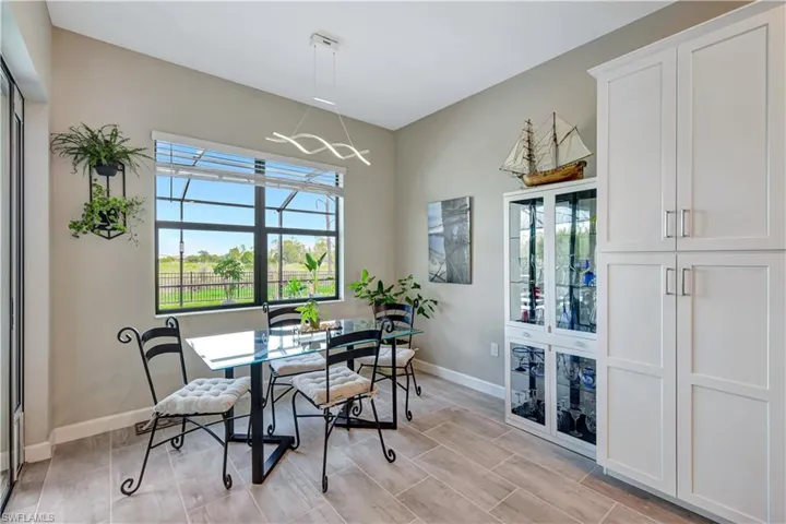 Dining space with baseboards, a chandelier, and wood finish floors