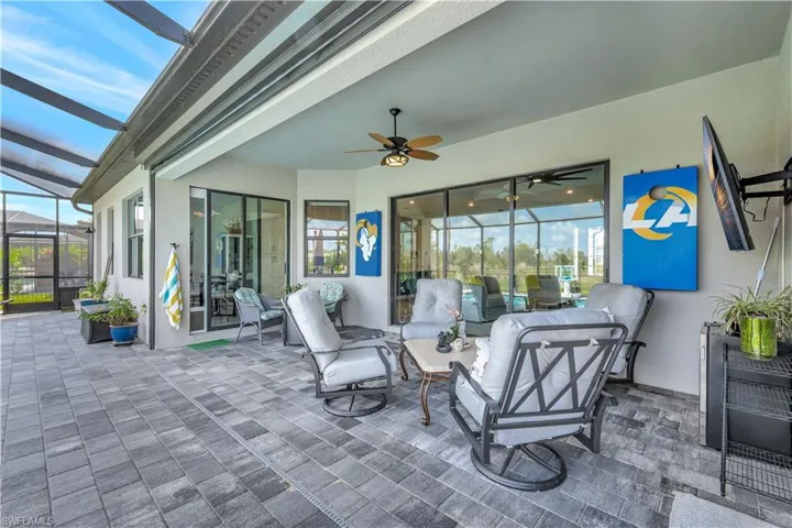 View of patio / terrace featuring ceiling fan, glass enclosure, and an outdoor living space