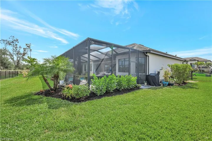 Rear view of property featuring stucco siding and glass enclosure