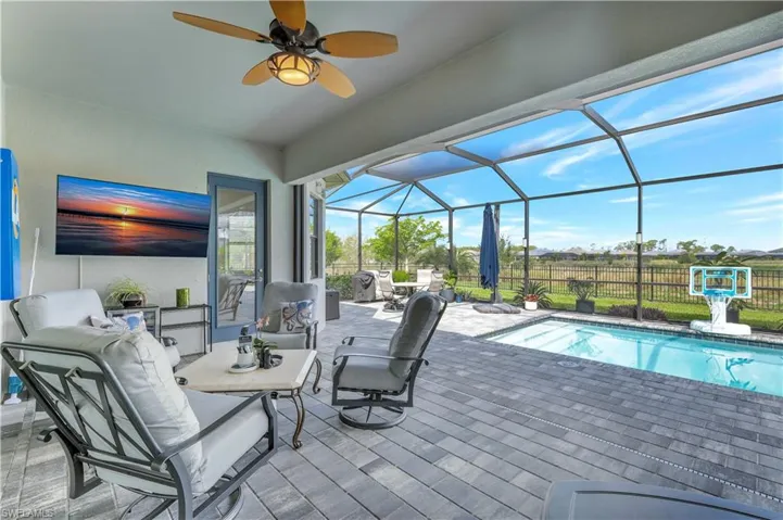 View of patio with a ceiling fan and glass enclosure