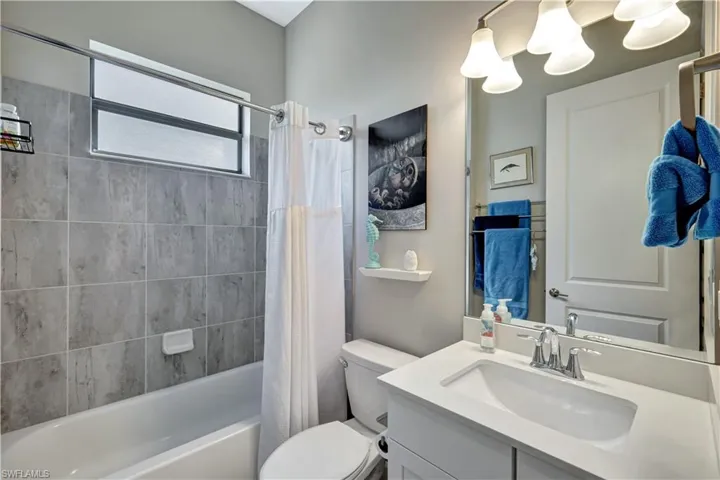 Full bath with toilet, vanity, and shower / bath combo