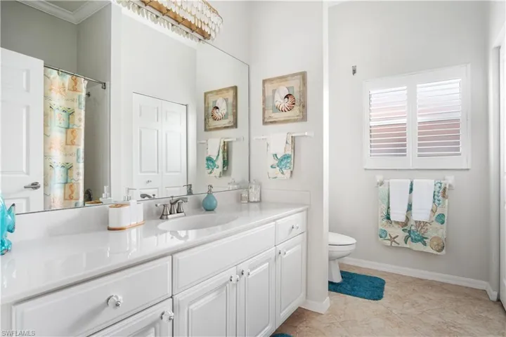 Bathroom with vanity, light tile patterned floors, a shower with curtain, and crown molding