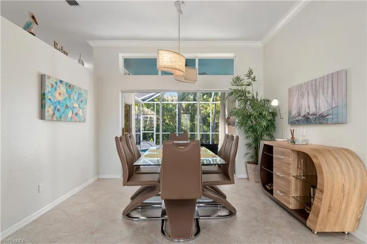 Dining space with crown molding, light tile patterned floors, and a sunroom