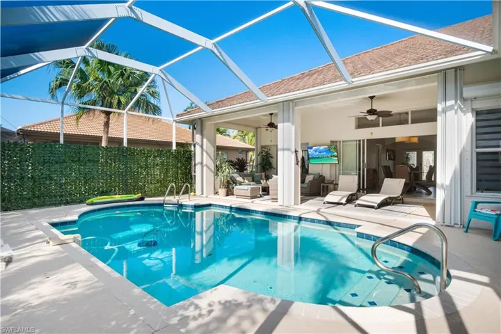 View of pool with ceiling fan, outdoor lounge area, a patio, a sunroom, and a lanai