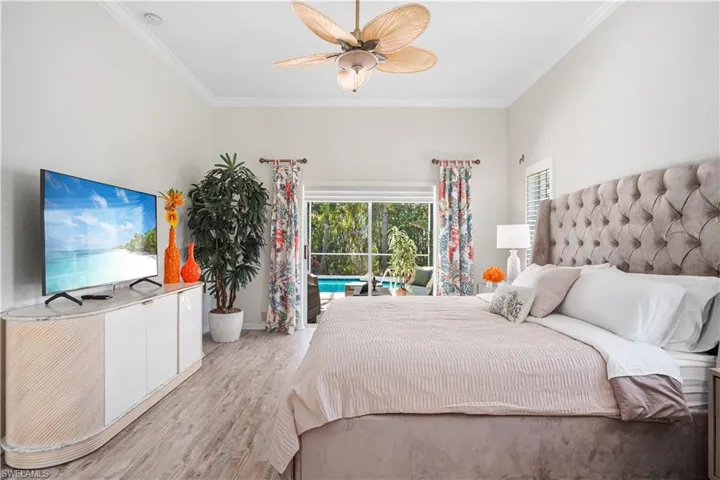 Bedroom featuring ornamental molding, wood finished floors, ceiling fan, and access to outside
